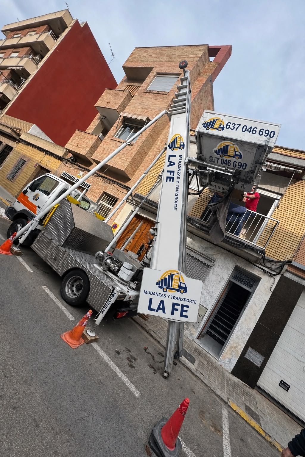 Camión de Mudanzas La Fe con elevador de fachada trabajando en Llíria