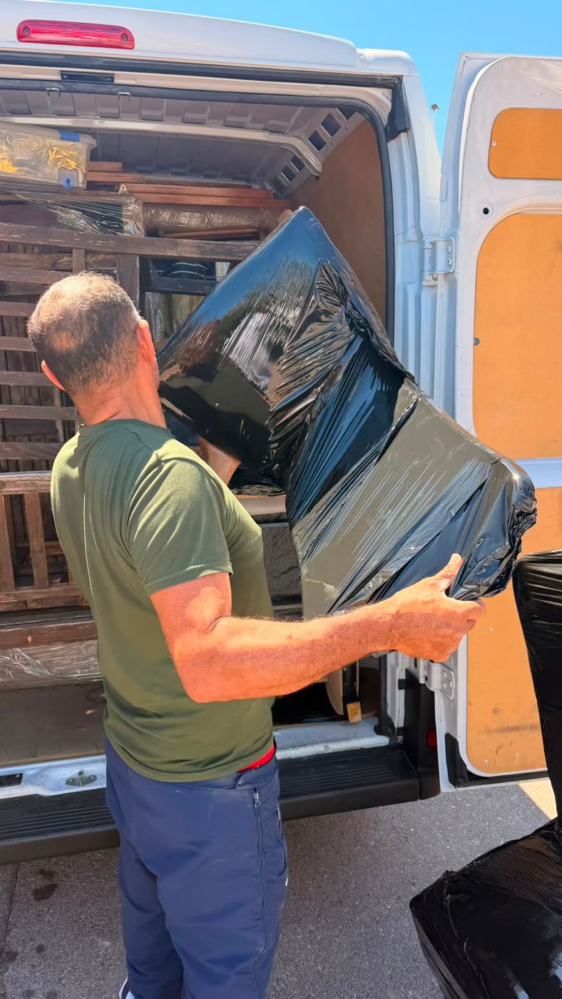 Operario de La Fe cargando muebles protegidos en la furgoneta
